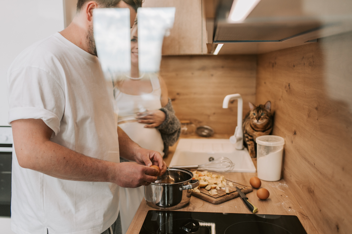 Couple cuisinant dans une cuisine avec hotte, ambiance chaleureuse
